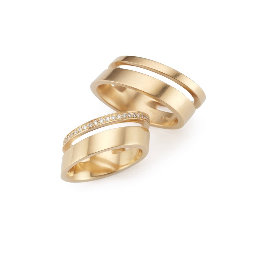 'Duett breit' ist ein außergewöhnlicher Unikat-Ehering aus dem Hause Grosche. Der oben im Bild abgebildete Ring ist aus 750er Gelbgold gefertigt, der unten gezeigte Ring aus 750er Gelbgold mit zusätzlichen diversen Brillanten.