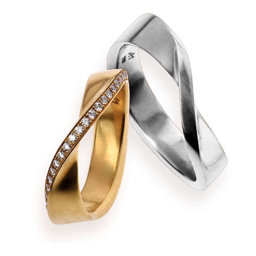 'Swing' ist ein besonderer Ehering aus dem Hause Grosche. Sein außergewöhnliches Design wurde bei dem linken Ring aus 750er Gelbgold gefertigt und mit Brillanten versetzt, der rechte Ring ist aus 750er Weißgold gefertigt.